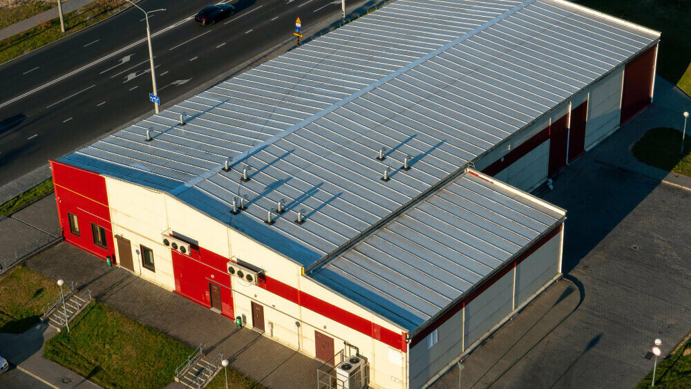 bird's eye view photo of a red and white commercial building with commercial roofing