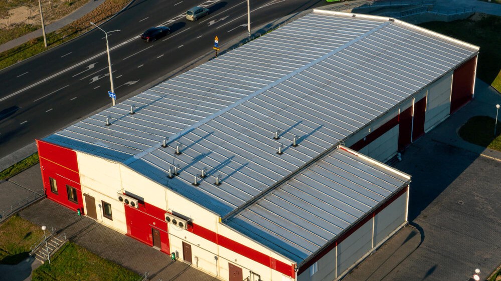 bird's eye view photo of a red and white commercial building with commercial roofing