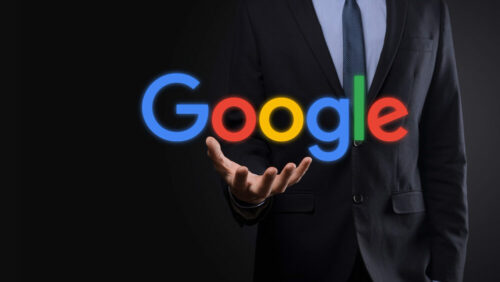 a man in suit holding the word google