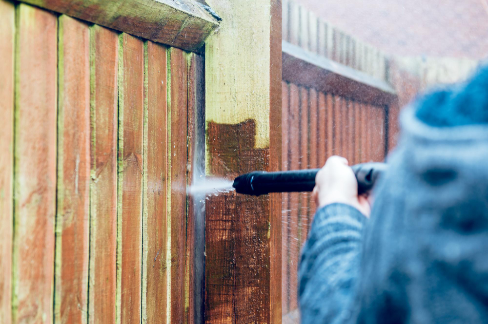 cleaning wood fence with pressure washer